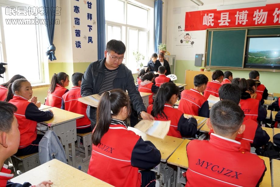 博物馆工作人员向参加活动的同学们发放宣传资料（包新田 摄）