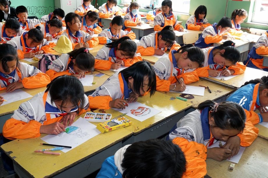 梅川镇中心小学参加活动的同学们在社教员的指导下专心绘图（包新田 摄）