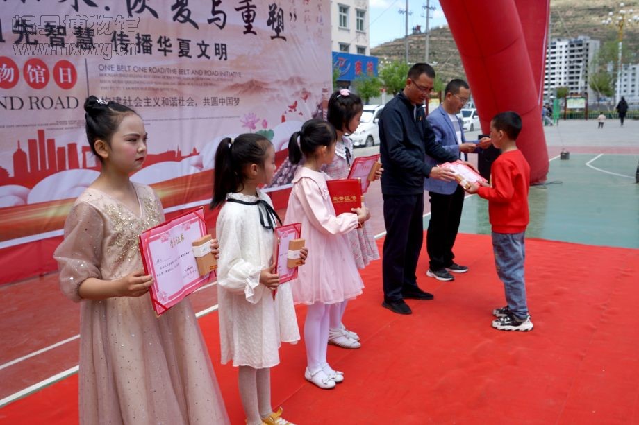 向参加“一颗红心向着党——红色诗歌咏唱活动”的节目表演者颁发荣誉证书（包新田 摄）